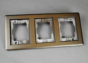 Here's an alt tag for the image: Triple gang brushed gold wall plate.