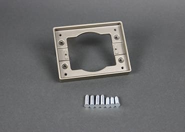 Here's an alt tag for the image: Gold metal wall plate with screws.