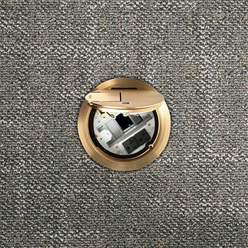 Here's an alt tag for the image: Brass floor-mounted electrical outlet open.