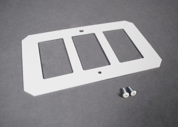 White triple switch plate with screws.